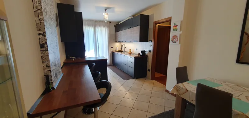 Cuisine vue depuis le bar, avec une fenêtre lumineuse