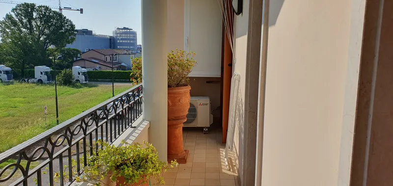 Balcon avec garde-corps et plantes, donnant sur la verdure